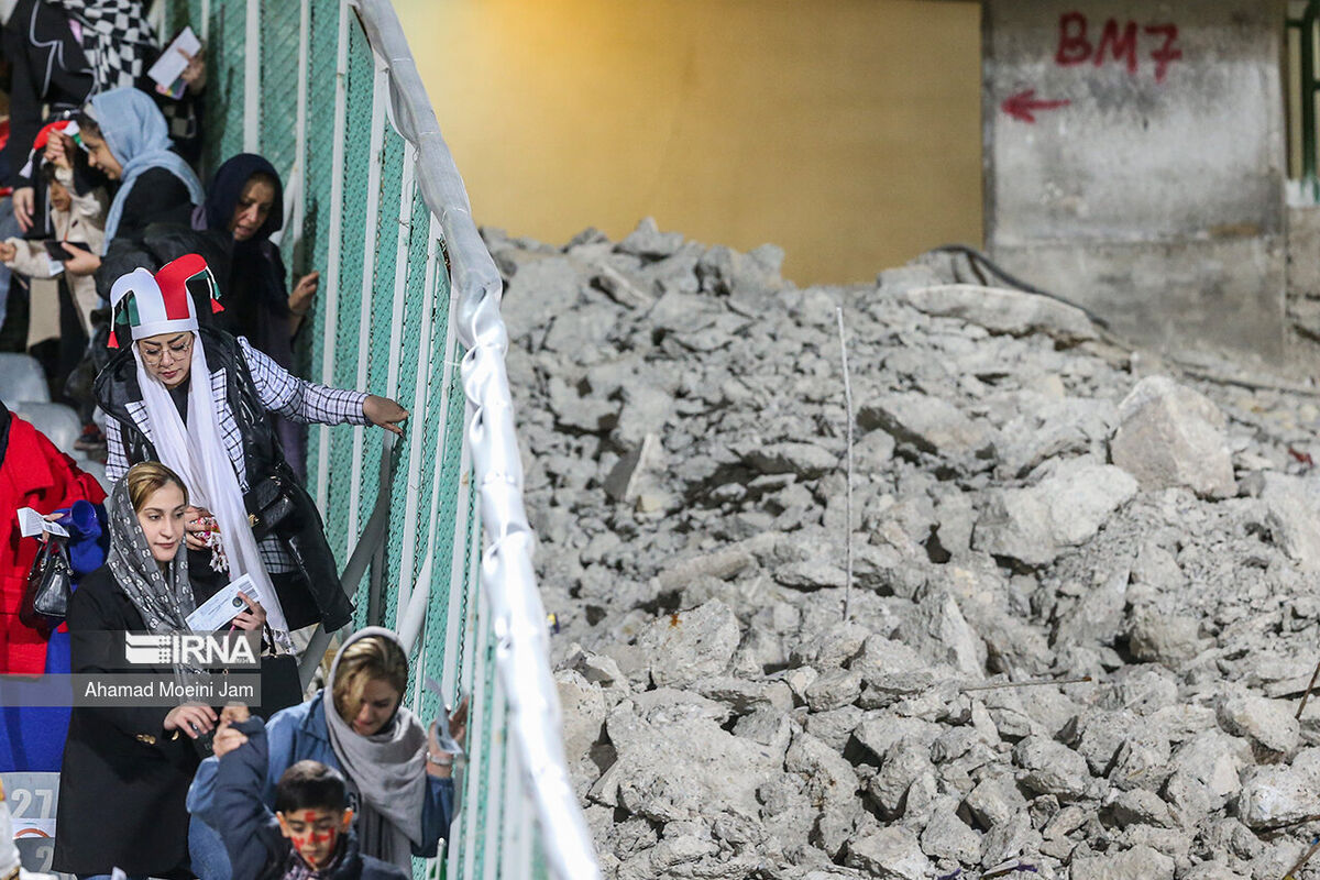 عکس| اینجا منطقه جنگی نیست، استادیوم آزادی است/ تصویری عجیب از زنان تماشاگر در کنار سکوهای مخروبه ورزشگاه آزادی